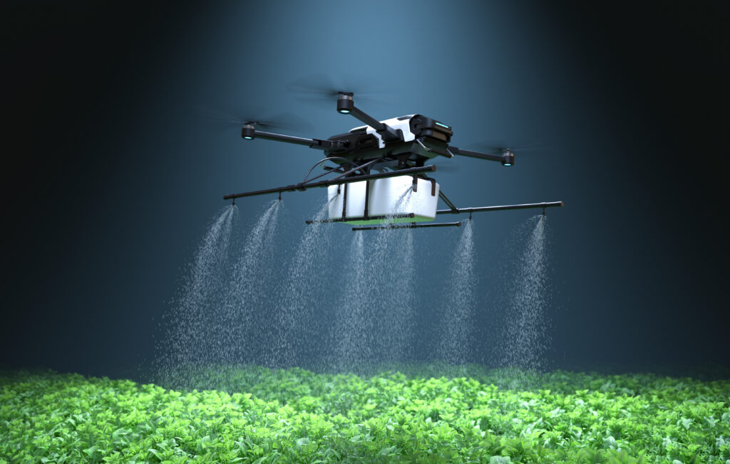 A drone can be seen sprinkling water over a lush green field